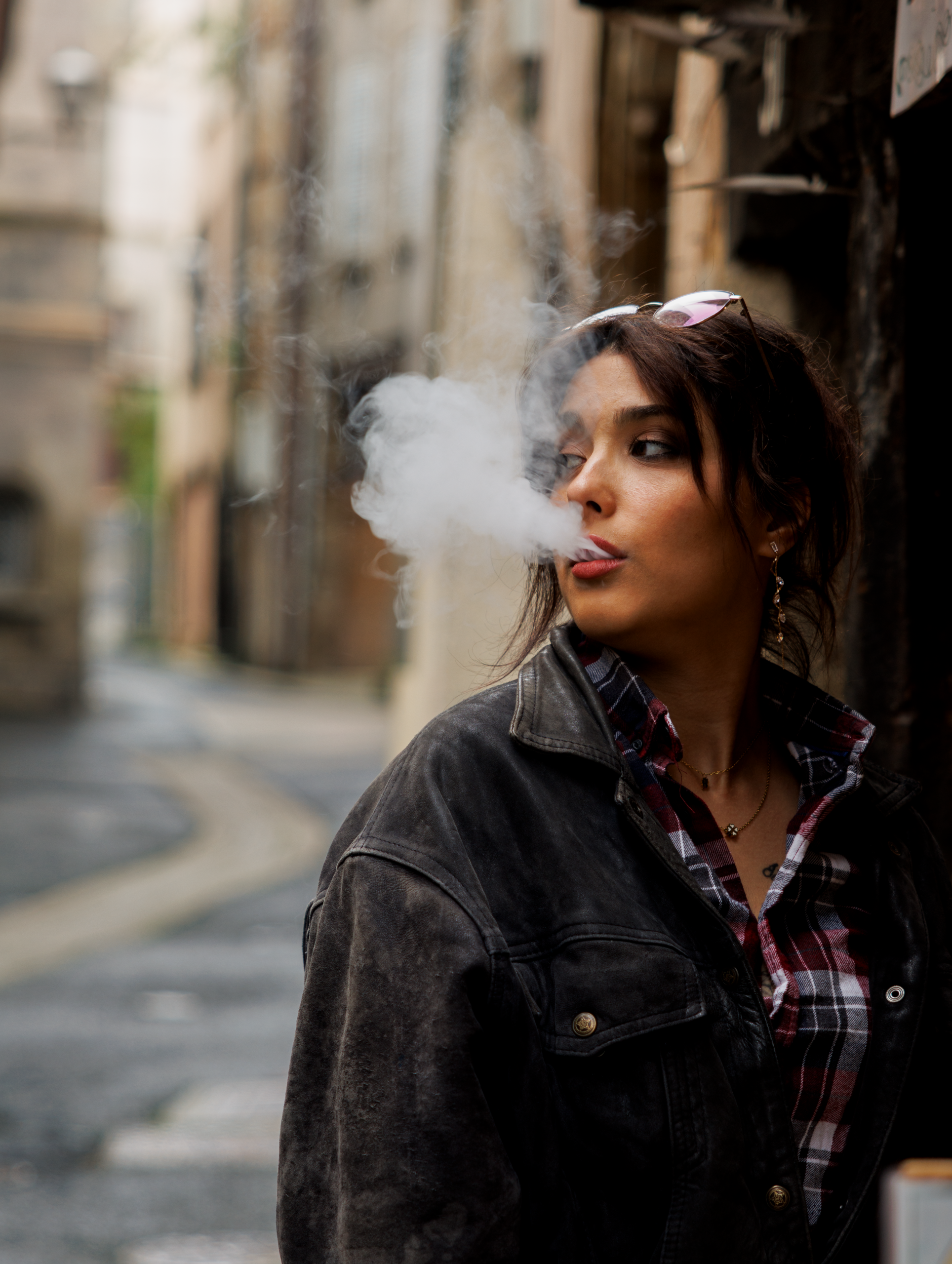 Photo lyon portrait - femme soufflant de la fumée dans une ruelle