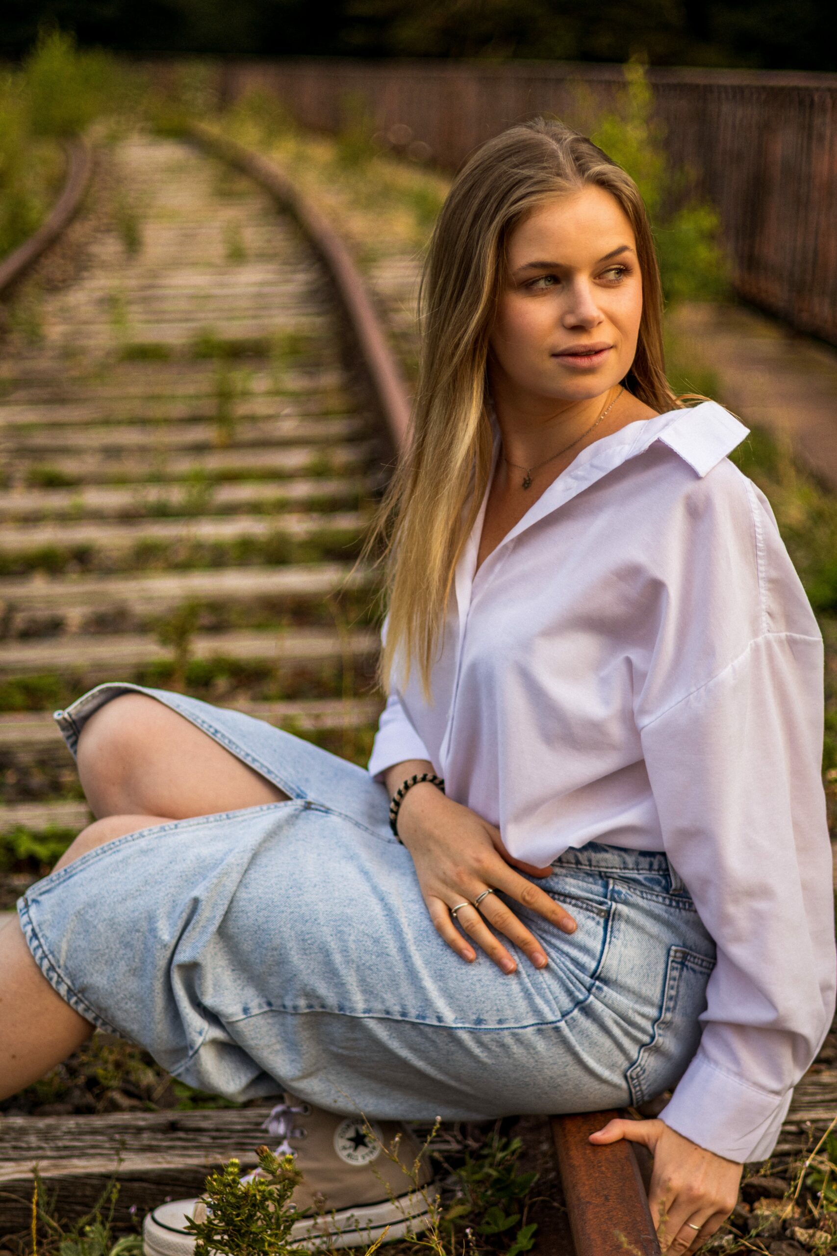 Photographe portrait - Femme assise au centre de ligne de chemin de fer